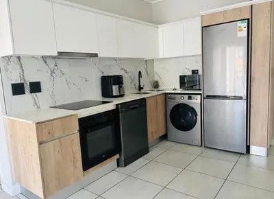 a kitchen with a stove and a dishwasher at 1 Bedroom Apartment at The Blyde, Pretoria in Pretoria