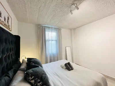 a bedroom with a bed and a couch and a window at Circa Urban Suite in Pretoria