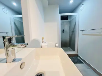a white bathroom with a sink and a shower at Circa Urban Suite in Pretoria