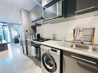 a kitchen with a washing machine and a sink at Circa Urban Suite in Pretoria