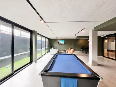 a pool table in a large room with windows at Circa Urban Suite in Pretoria