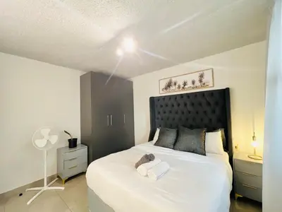 a bedroom with a white bed with a stuffed animal on it at Circa Urban Suite in Pretoria