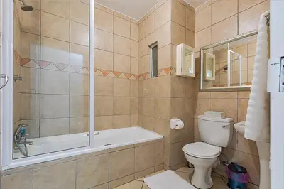 a bathroom with a tub and a toilet and a shower at Calmwood Stay in Midrand