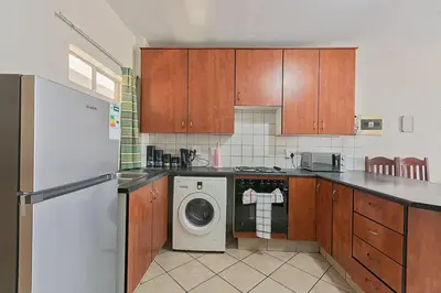 a kitchen with a refrigerator and a washer and a dishwasher at Calmwood Stay in Midrand