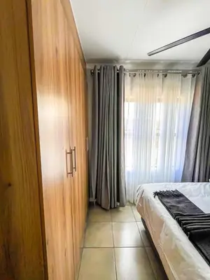 a bedroom with a bed and a wooden cabinet at chillasclub&Bnb in Nelspruit