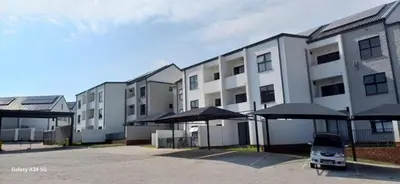 a row of buildings with umbrellas in a parking lot at chillasclub&Bnb in Nelspruit