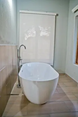 a large white tub in a bathroom with a window at Collen Pillar Hotels, Windsor Royale