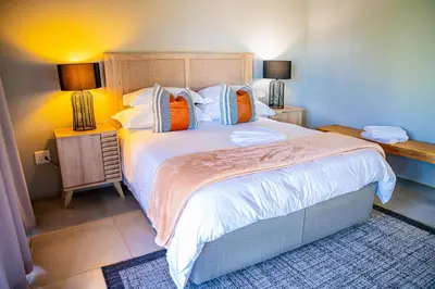 a bedroom with a large bed with orange and blue pillows at Collen Pillar Hotels, Windsor Royale