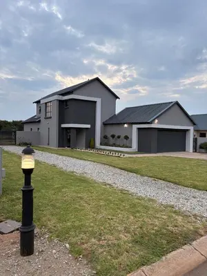 a house with a light pole in front of it at 202 on Crescent - Luxury Wildlife Escape in Hartbeespoort with Magaliesberg Mountain views in Hartbeespoort