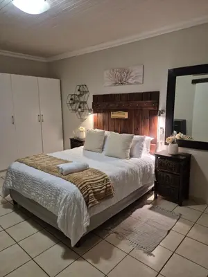 a bedroom with a large bed and a large mirror at YouRHome in Pretoria