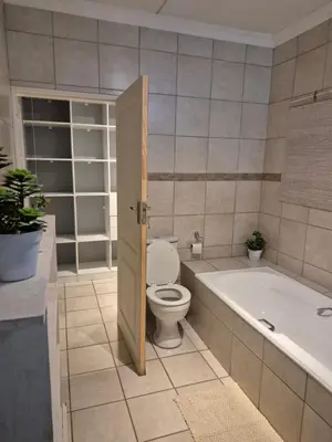 a bathroom with a toilet and a bath tub at YouRHome in Pretoria