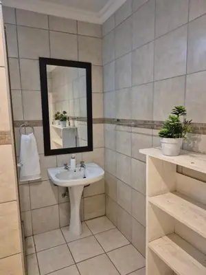 a bathroom with a sink and a mirror at YouRHome in Pretoria