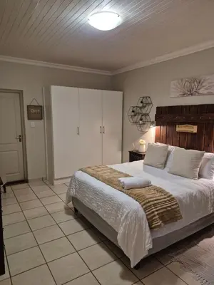 a bedroom with a large bed and white cabinets at YouRHome in Pretoria