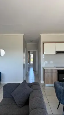 a living room with a couch and a kitchen at Lagoon Serenity Suite in Pretoria