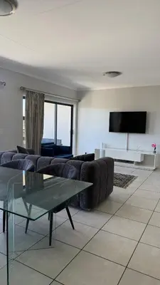 a living room with a couch and a table at Lagoon Serenity Suite in Pretoria