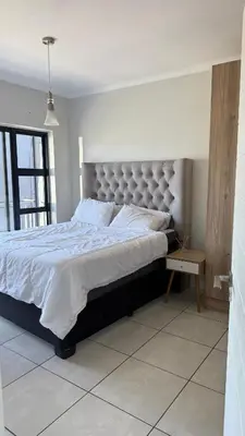a bedroom with a large bed with a large headboard at Lagoon Serenity Suite in Pretoria