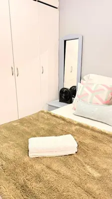 a white bedroom with a bed with a towel on it at 33OnPangolin B&B in Nelspruit