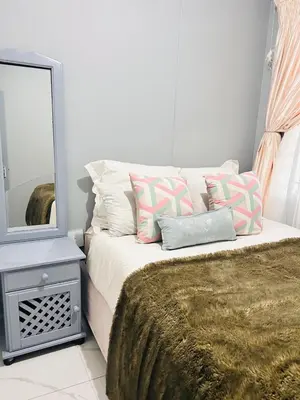 a bedroom with a bed with a mirror and a bed sidx sidx sidx at 33OnPangolin B&B in Nelspruit