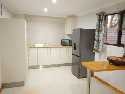 a kitchen with a refrigerator and a table at Waterhole Lodge Unit 2 in Malelane