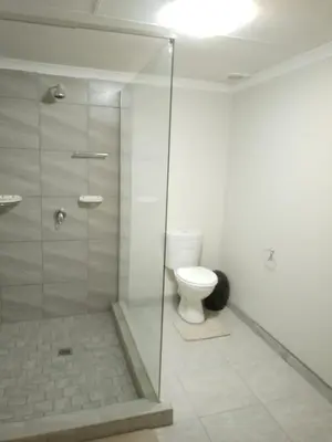 a bathroom with a toilet and a glass shower at Waterhole Lodge Unit 2 in Malelane