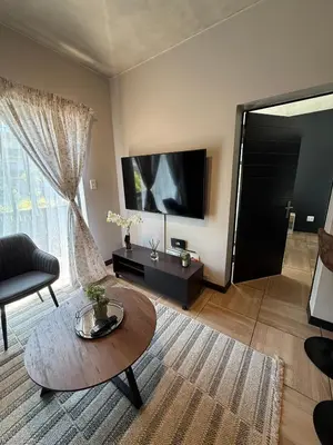 a living room with a table and a large window at The Precinct Luxury Apartments in Kyalami