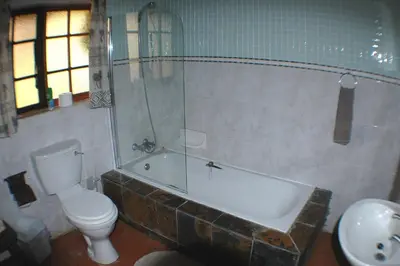 a bathroom with a tub and a toilet and a sink at Trees Too Guest Lodge in Komatipoort