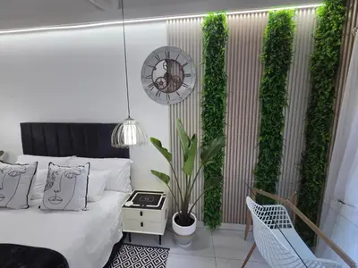 a bedroom with a bed and a green wall at Indulge Deluxe Accommodation in Middelburg