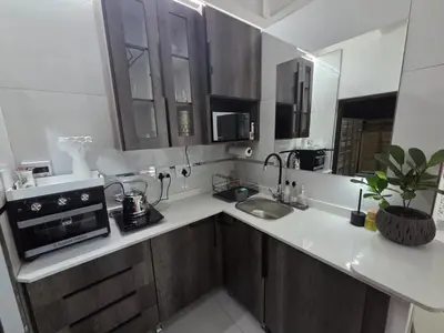 a kitchen with a sink and a microwave at Indulge Deluxe Accommodation in Middelburg
