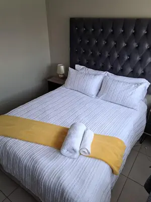 a bedroom with a bed with two towels on it at GP Mgudlwa in Pretoria