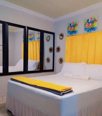 a bedroom with a bed with a yellow blanket on it at Kiba guest house