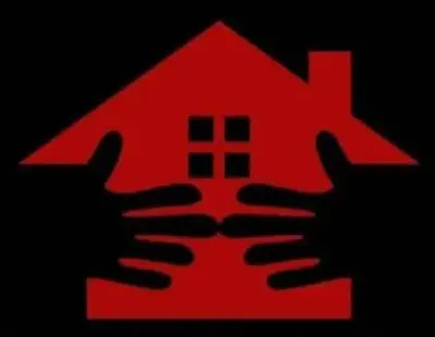 a red house with two hands holding up it at Kiba guest house