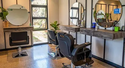 a salon with two chairs and a television and mirrors at Home away from home in the heart of waterfall in Midrand