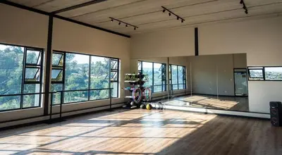 an empty room with windows and a large room with wooden floors at Home away from home in the heart of waterfall in Midrand