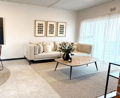 a living room with a couch and a coffee table at Home away from home in the heart of waterfall in Midrand