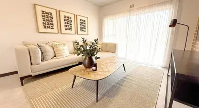 a living room with a couch and a table at Home away from home in the heart of waterfall in Midrand