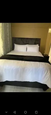 a bed with white sheets and pillows in a bedroom at Guest house at 17 Arnot