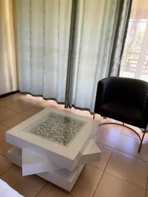 a white table and a black chair in a room at Guest house at 17 Arnot