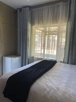 a bedroom with a large white bed with a window at Guest house at 17 Arnot