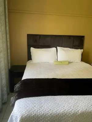 a bedroom with a large bed with two pillows at Guest house at 17 Arnot