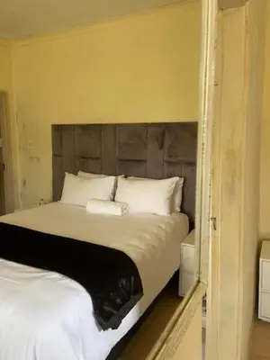 a bedroom with a large bed with a wooden headboard at Guest house at 17 Arnot