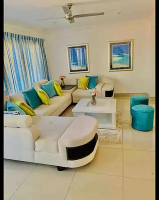 a living room with a white couch and blue and yellow pillows at Damview guesthouse in Hartbeespoort