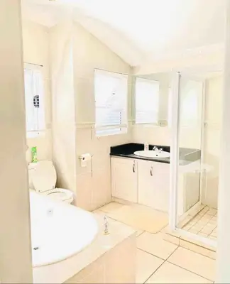 a white bathroom with a toilet and a sink at Damview guesthouse in Hartbeespoort