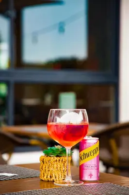 a glass of wine sitting on top of a table at The Regency Exclusive Apartment in Pretoria