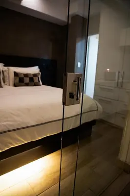 a glass door leading to a bedroom with a bed at The Regency Exclusive Apartment in Pretoria