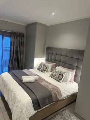 a bedroom with a large bed with a large headboard at Modern Comfort in the Heart of Pretoria the Jacaranda City in Pretoria