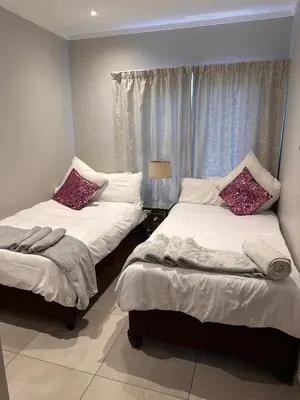 a bedroom with two beds and a window at Modern Comfort in the Heart of Pretoria the Jacaranda City in Pretoria