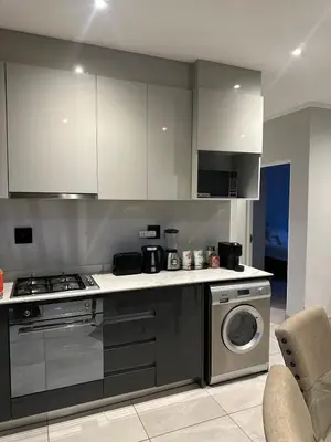 a kitchen with a stove and a washing machine at Modern Comfort in the Heart of Pretoria the Jacaranda City in Pretoria