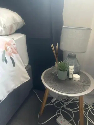 a table with a lamp and plants on it next to a bed at Kumba Mzansi in Musina