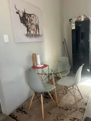 a dining room with a glass table and chairs at Kumba Mzansi in Musina
