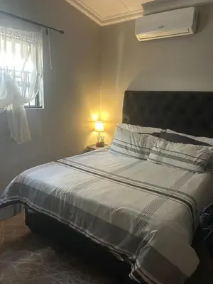 a bedroom with a bed and a window with a light at Kumba Mzansi in Musina
